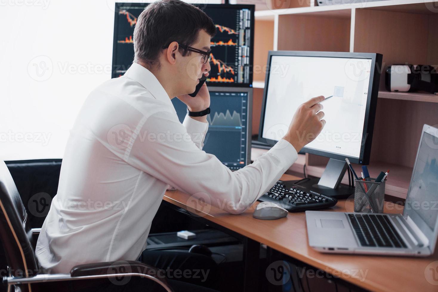 Stockbroker in shirt is working in a monitoring room with display screens. Stock Exchange Trading Forex Finance Graphic Concept. Businessmen trading stocks online photo