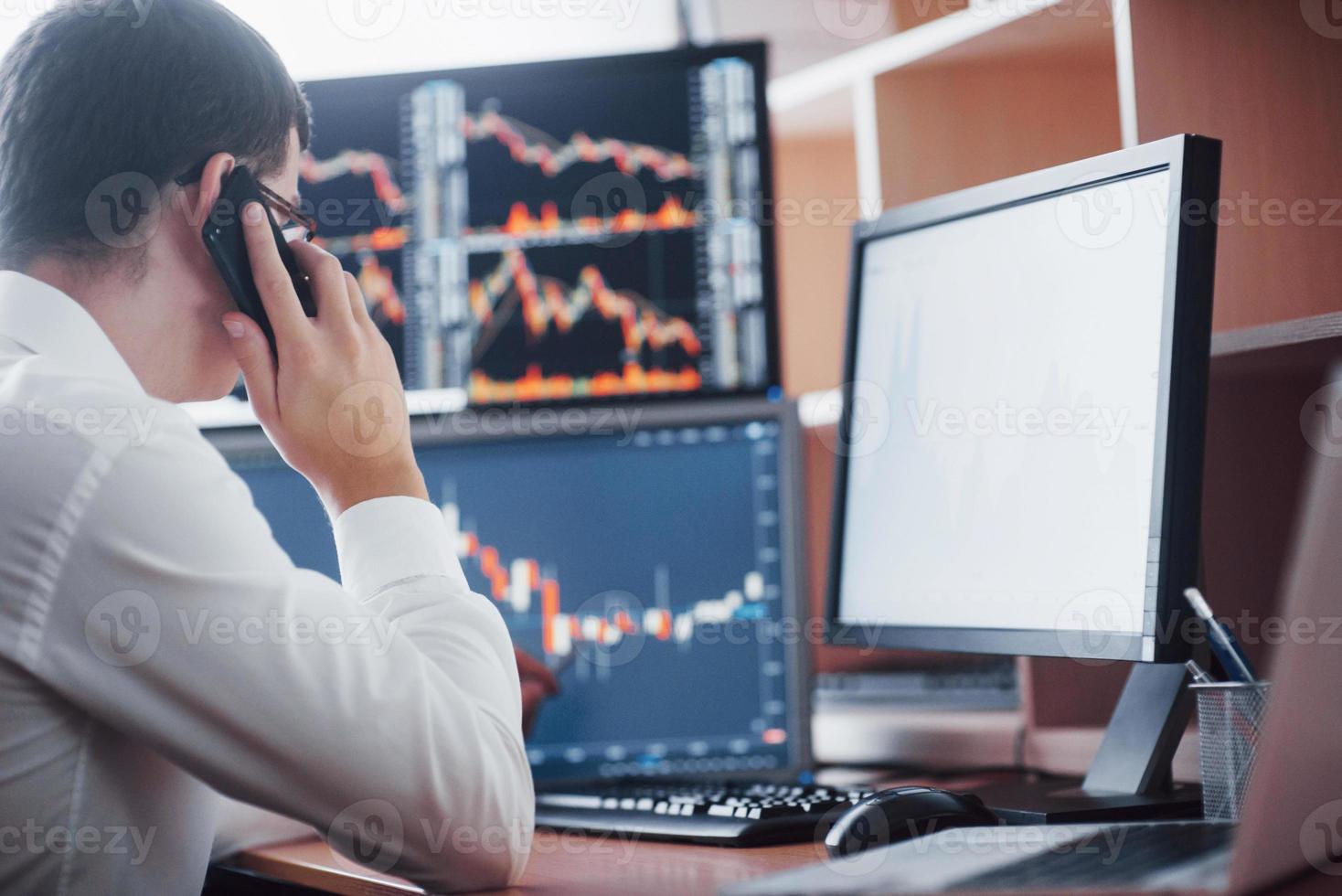 Stockbroker in shirt is working in a monitoring room with display screens. Stock Exchange Trading Forex Finance Graphic Concept. Businessmen trading stocks online photo