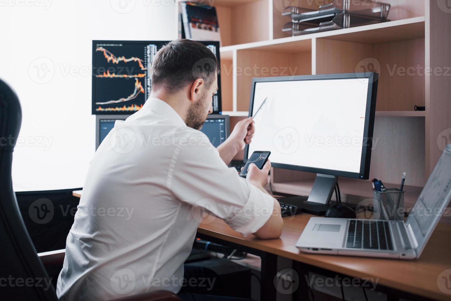 Stockbroker in shirt is working in a monitoring room with display screens. Stock Exchange Trading Forex Finance Graphic Concept. Businessmen trading stocks online photo