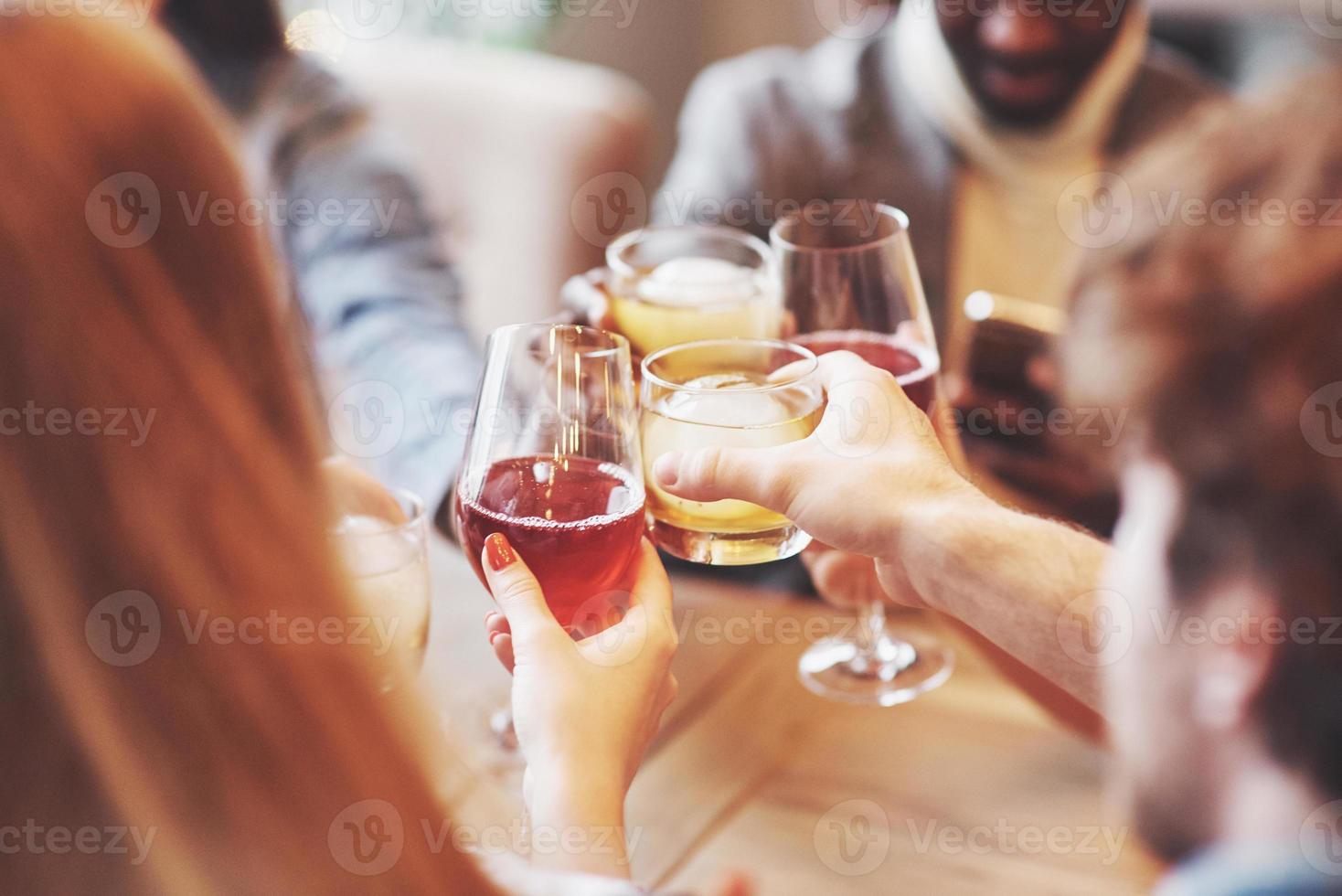 Manos de personas con vasos de whisky o vino, celebrando y brindando en honor a la boda u otra celebración. foto