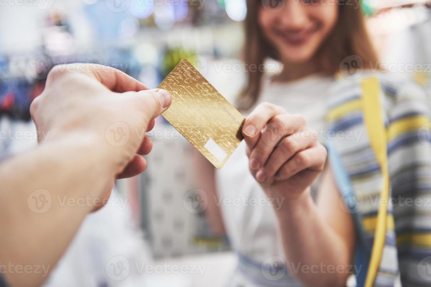 mujer de compras. mujer feliz con bolsas de la compra y tarjeta de crédito disfrutando de compras. consumismo, compras, concepto de estilo de vida foto