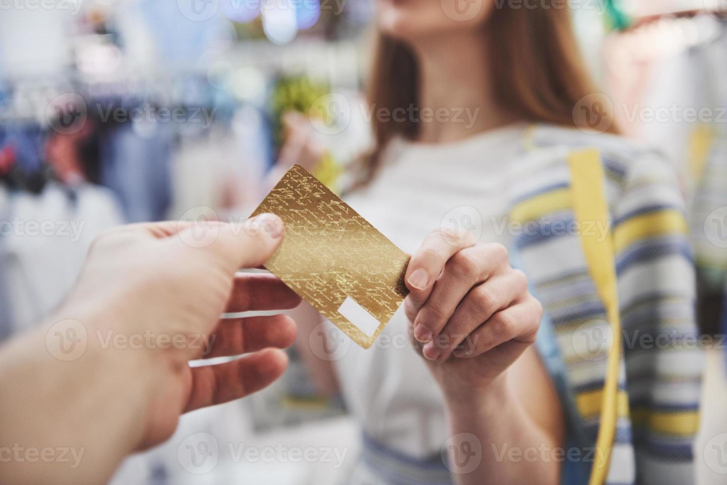 mujer de compras. mujer feliz con bolsas de la compra y tarjeta de crédito disfrutando de compras. consumismo, compras, concepto de estilo de vida foto