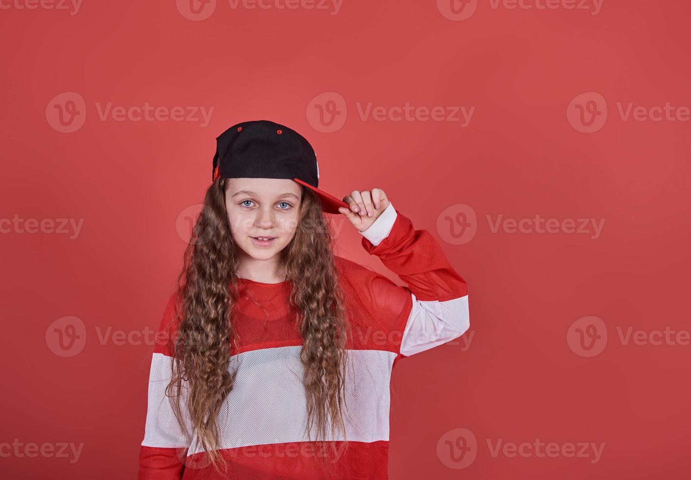 Joven hermosa linda chica bailando sobre fondo rojo, moderno y delgado estilo hip-hop adolescente saltando foto