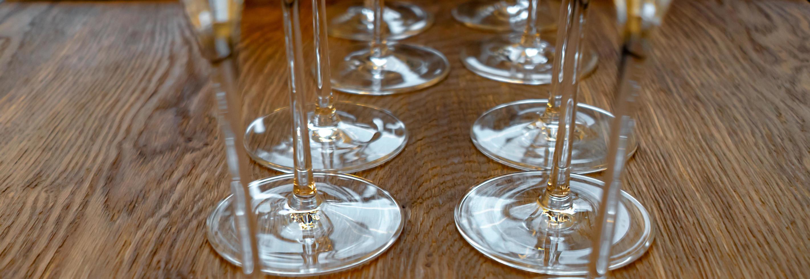 Two rows of wine glasses on a wooden table photo