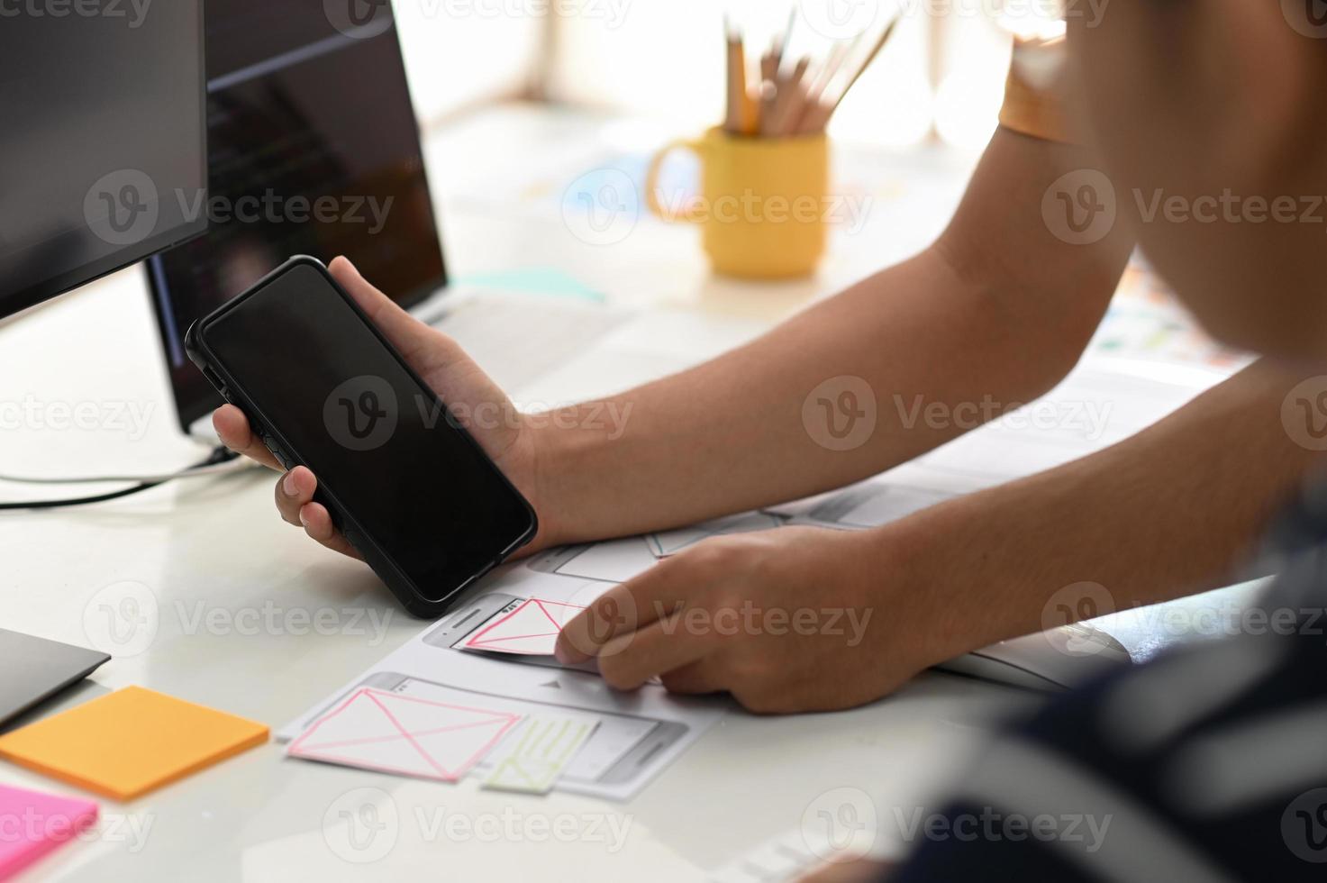 equipo de diseñadores de aplicaciones para teléfonos inteligentes que trabajan juntos para diseñar un nuevo proyecto. foto