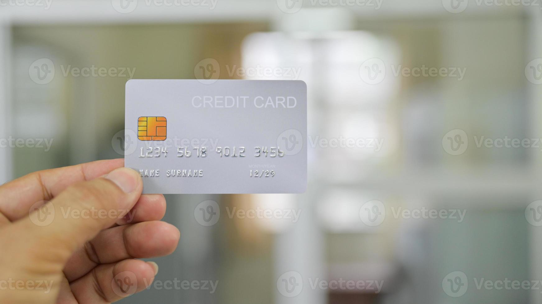 primer plano de la mano que muestra la tarjeta de crédito. foto