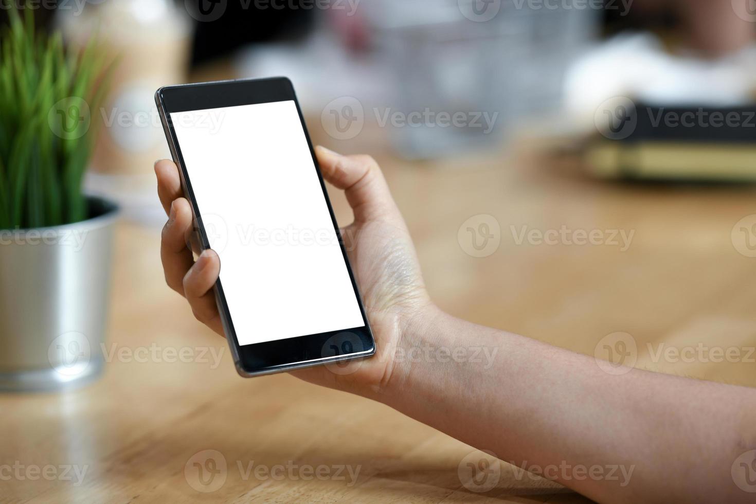 chica con un teléfono inteligente móvil de pantalla en blanco en la mano. foto