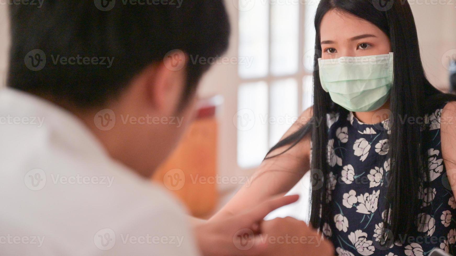Asian woman wearing a mask is discussing her work with her colleagues. photo