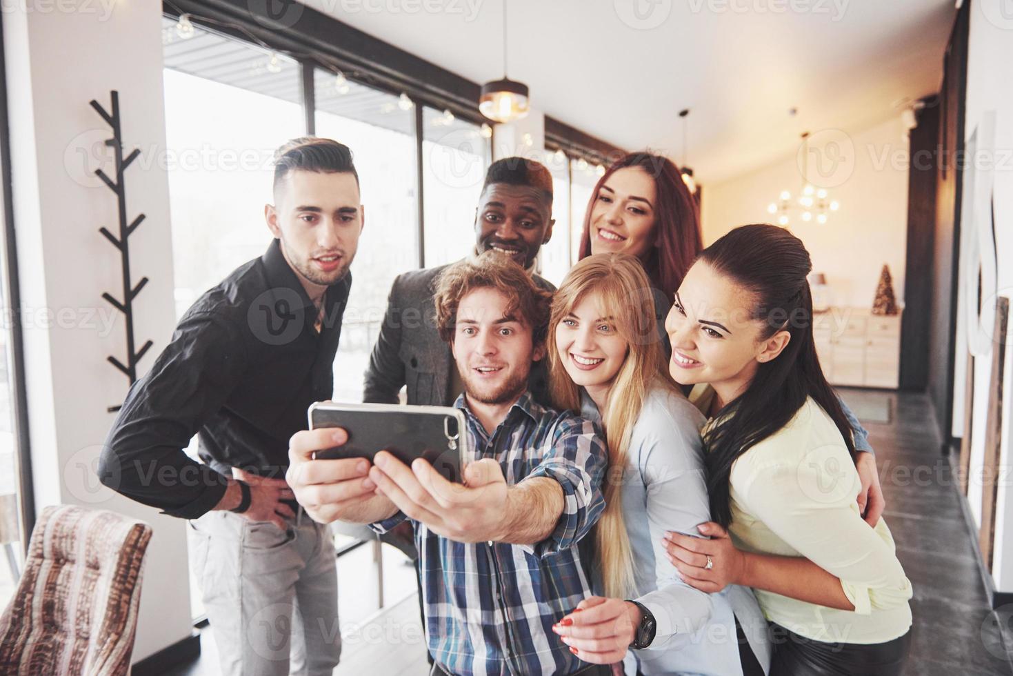 Selfie of young smiling teenagers having fun together. Best friends taking selfie outdoors with backlighting. Happy friendship concept with young people having fun together photo