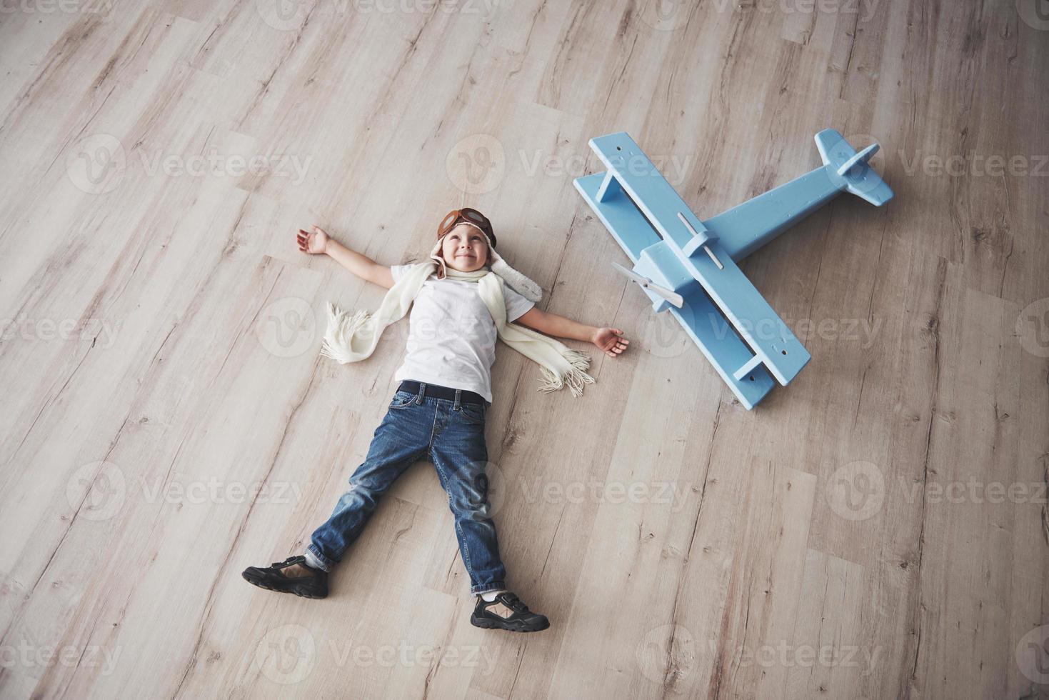 niño finge ser piloto. niño divirtiéndose en casa. concepto de viaje y vacaciones de verano. retrato de vista superior foto