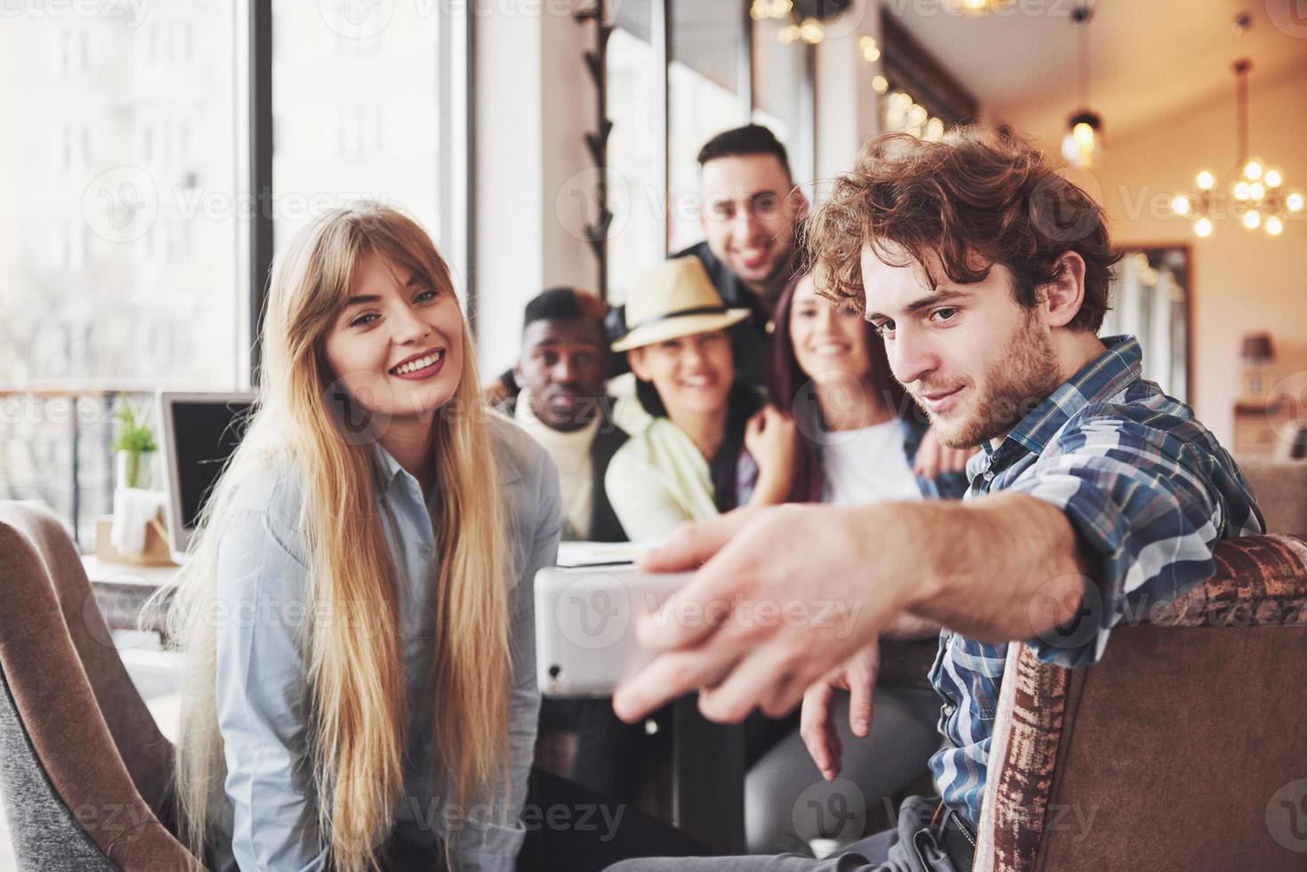 Selfie of young smiling teenagers having fun together. Best friends taking selfie outdoors with backlighting. Happy friendship concept with young people having fun together photo