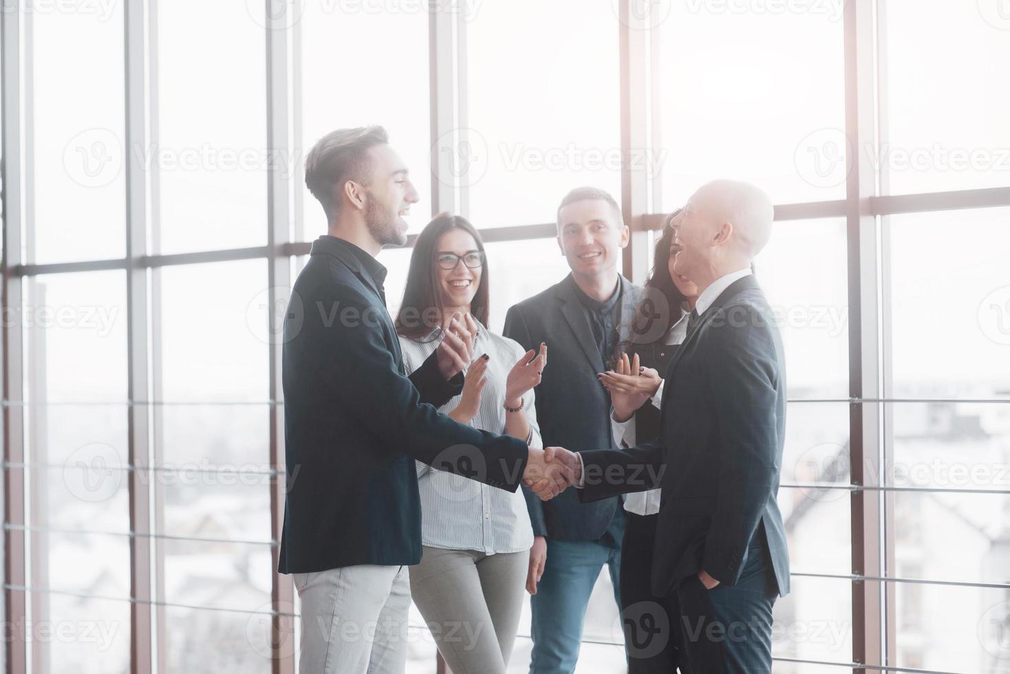 Dos hombre de negocios confiado dándose la mano durante una reunión en la oficina, el éxito, el trato, el saludo y el concepto de socio foto