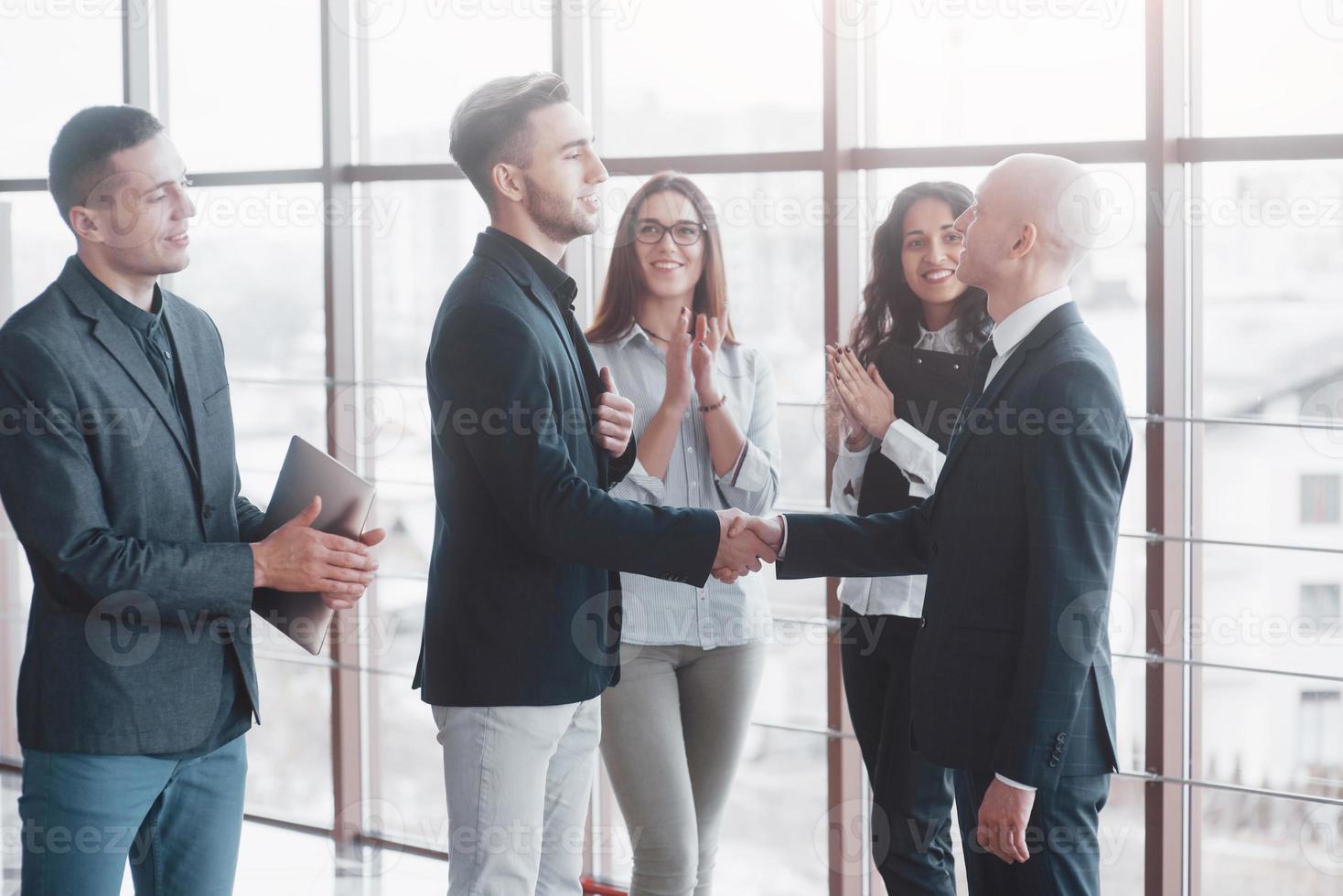 Dos hombre de negocios confiado dándose la mano durante una reunión en la oficina, el éxito, el trato, el saludo y el concepto de socio foto
