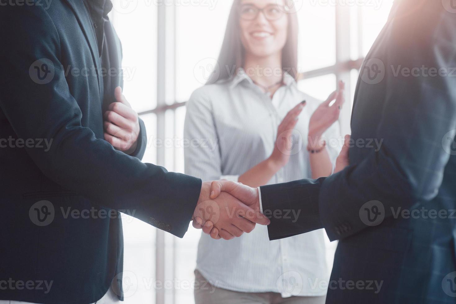 Dos hombre de negocios confiado dándose la mano durante una reunión en la oficina, el éxito, el trato, el saludo y el concepto de socio foto