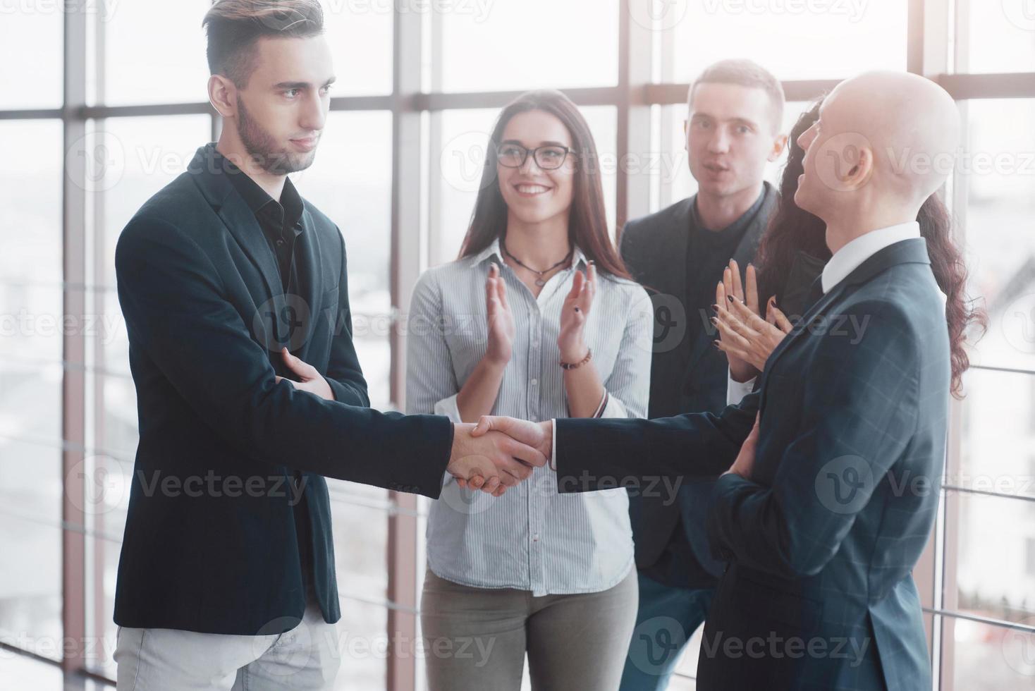 Dos hombre de negocios confiado dándose la mano durante una reunión en la oficina, el éxito, el trato, el saludo y el concepto de socio foto