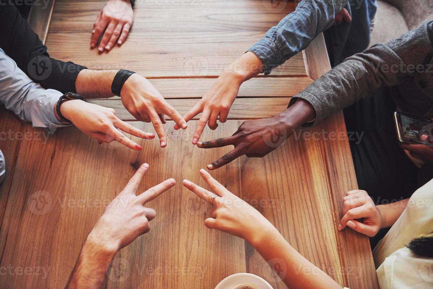 Close up top view of young people putting their hands together. Friends Doing a Star Shape with fingers showing unity and teamwork photo