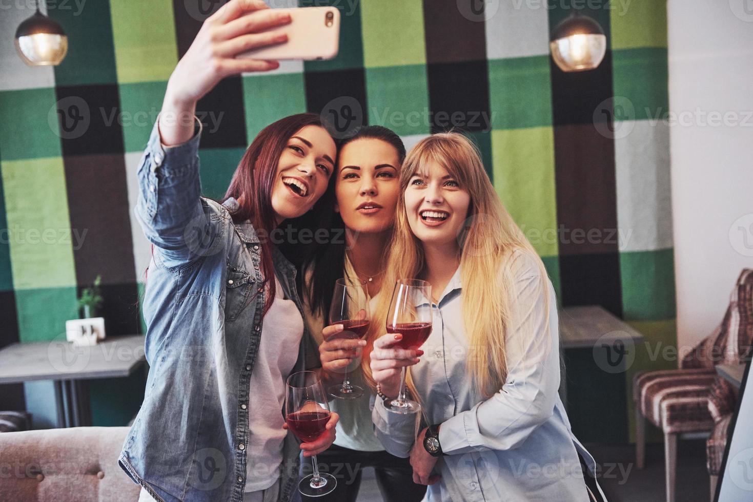 Imagen que presenta feliz grupo de amigos con vino tinto tomando selfie foto