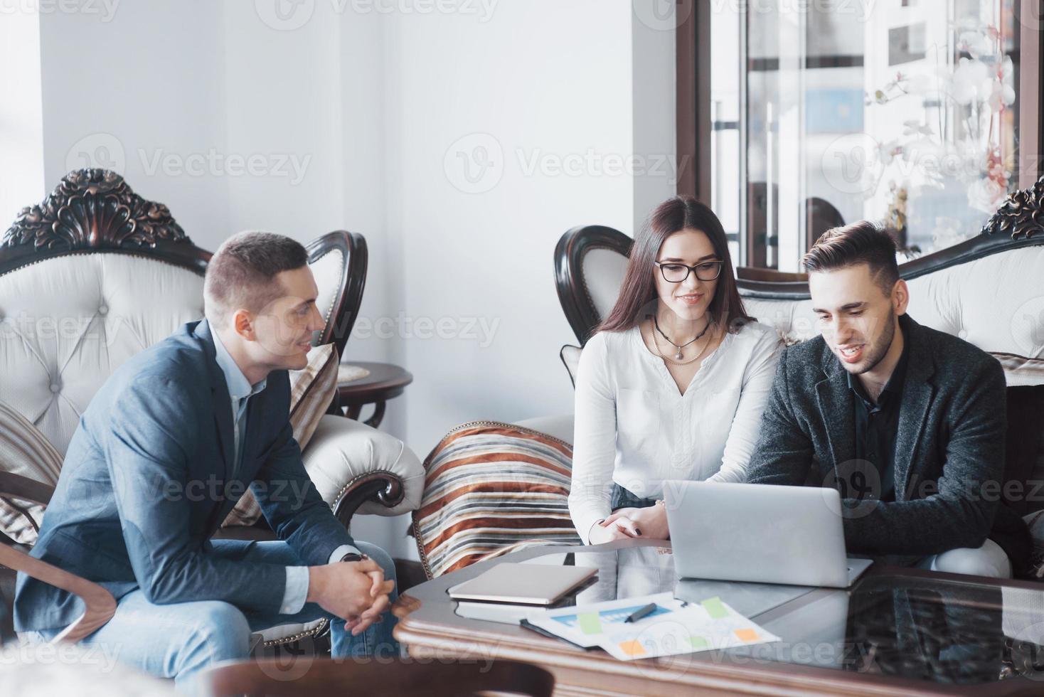 Young team of coworkers making great business discussion in modern coworking office. Teamwork people concept photo