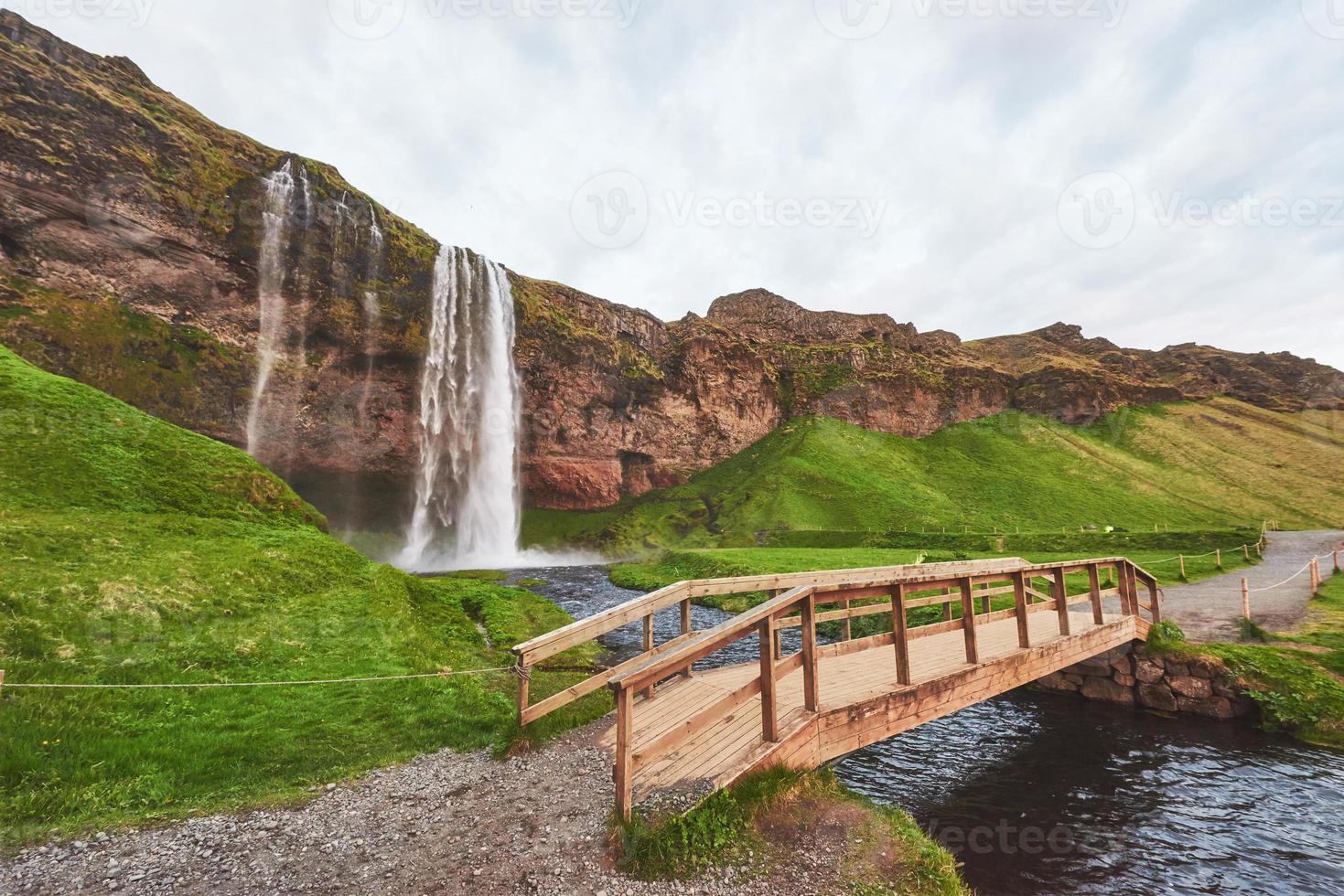 Cascada de Seljalandfoss al atardecer. puente sobre el río. naturaleza fantástica. Islandia. foto