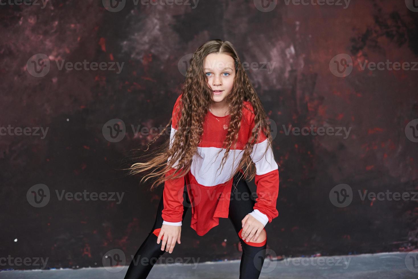 Hermosa joven bailando en ropa de moda sobre un fondo grunge foto