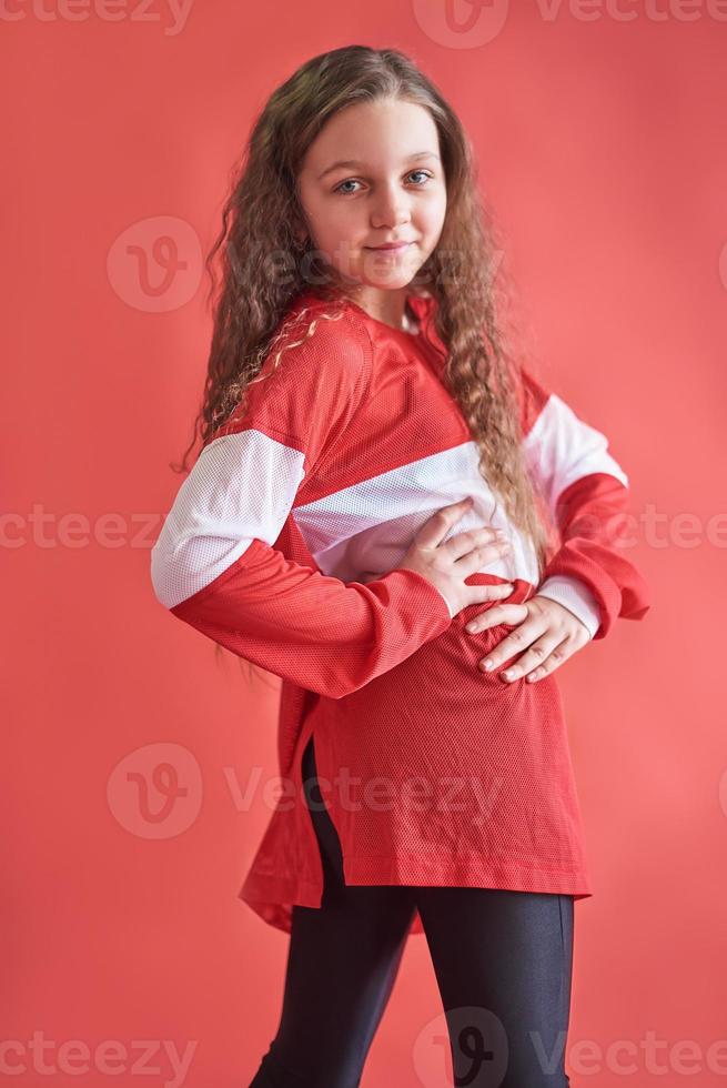 Joven mujer urbana bailando sobre fondo rojo, moderno estilo hip-hop delgado adolescente foto