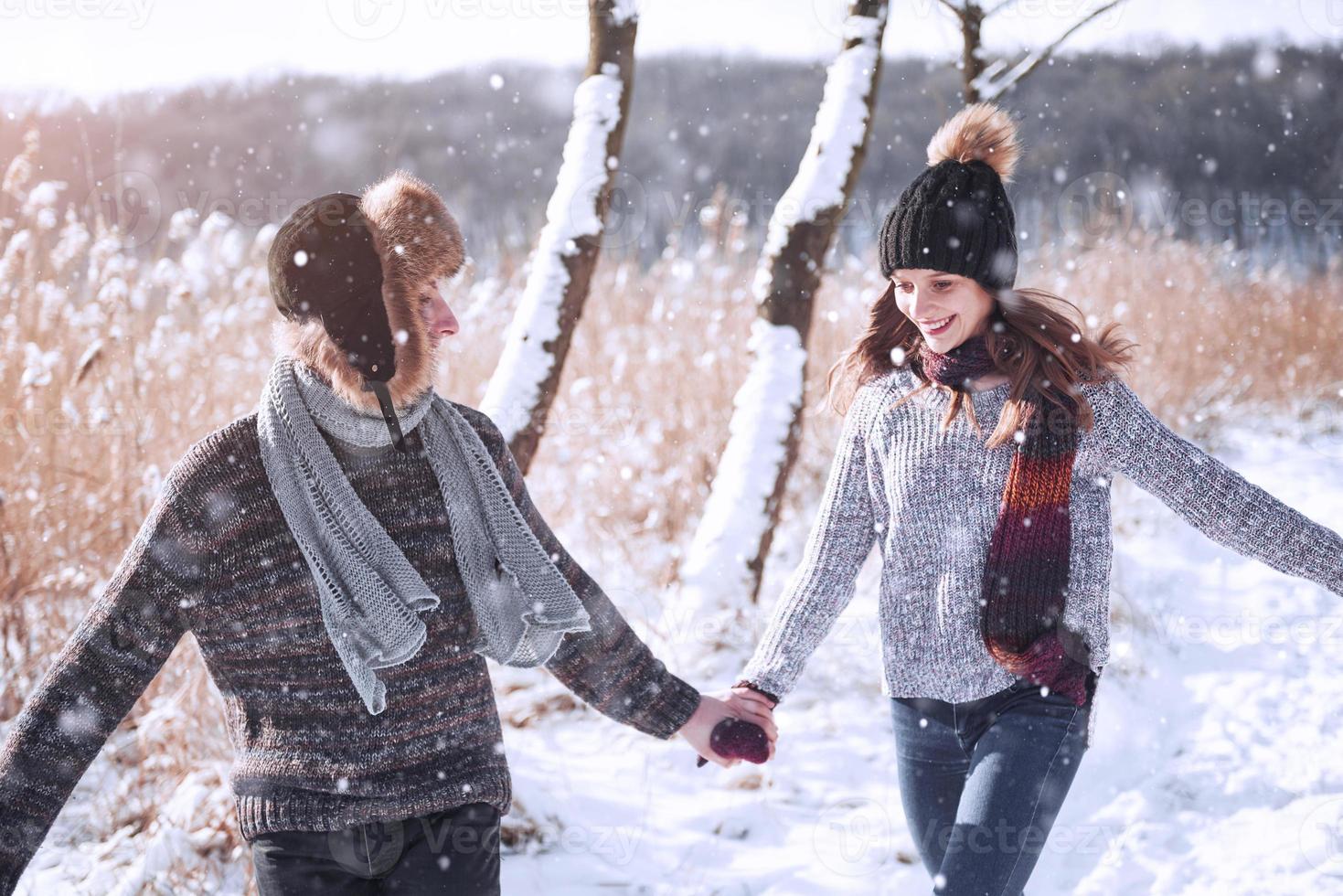 Couple has fun and laughs. kiss. Young hipster couple hugging each other in winter park. Winter love story, a beautiful stylish young couple. Winter fashion concept with boyfriend and girlfriend photo