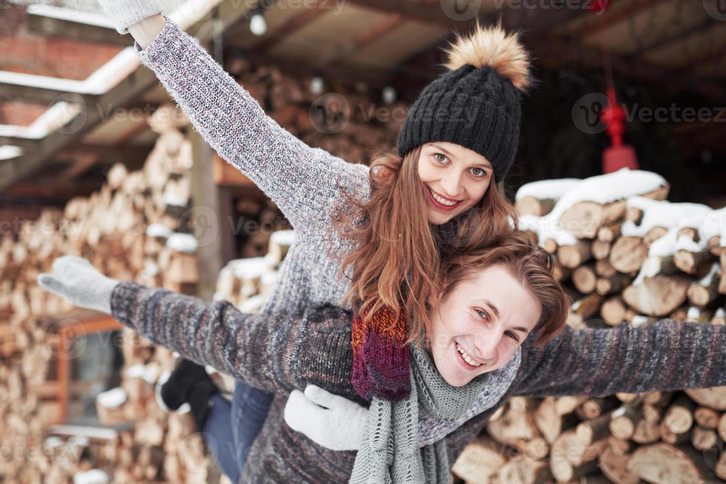 Pareja joven alegre en una cabaña en un romántico paisaje en invierno foto