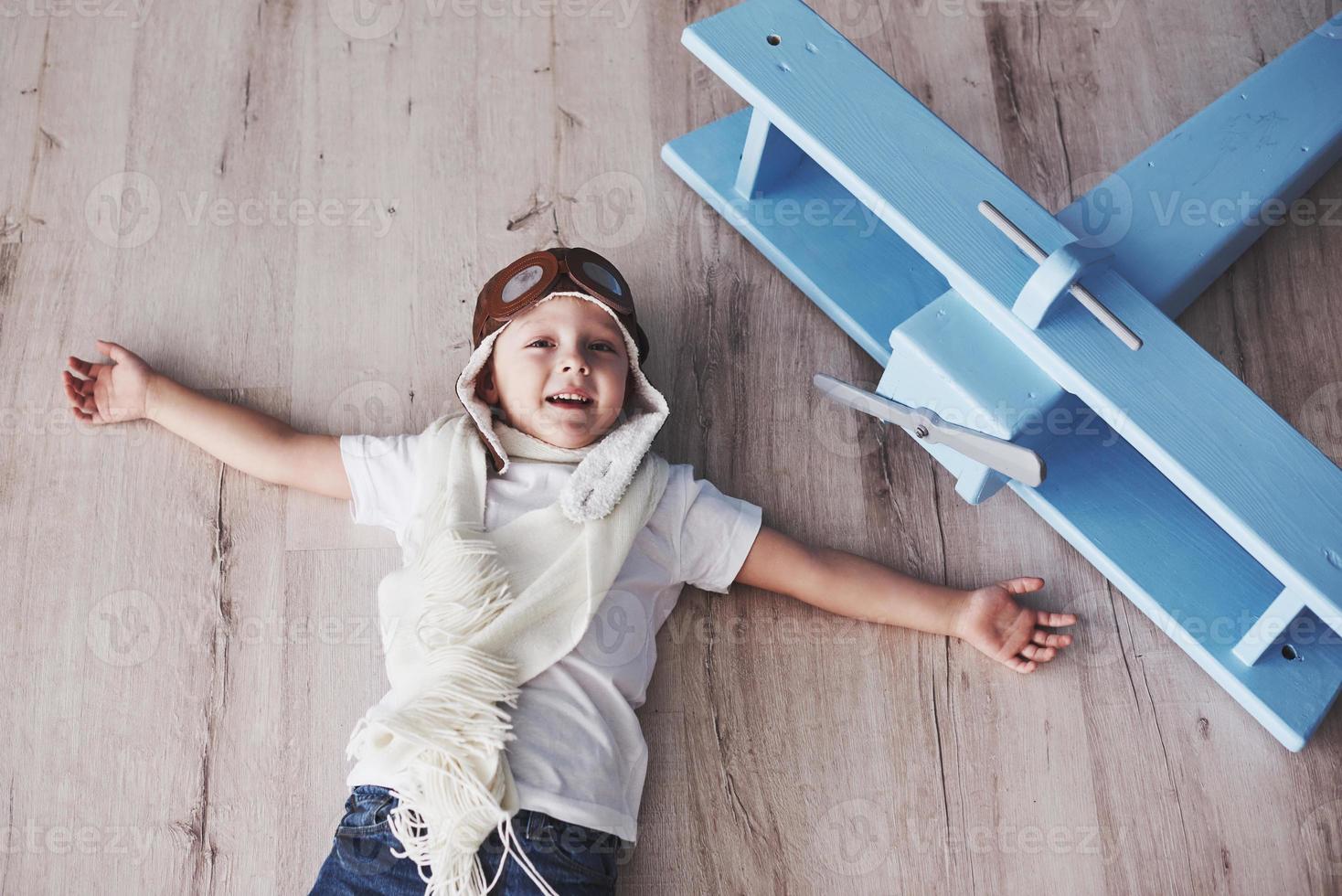 Child pretend to be pilot. Kid having fun at home. Vintage pilot and travel concept. Top view portrait photo