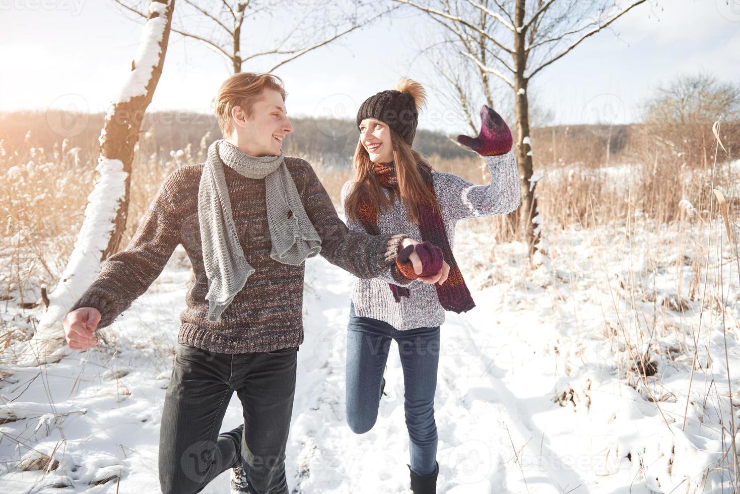 la pareja se divierte y se ríe. Beso. Pareja joven inconformista abrazándose en Winter Park. historia de amor de invierno, una hermosa joven pareja con estilo. concepto de moda de invierno con novio y novia foto