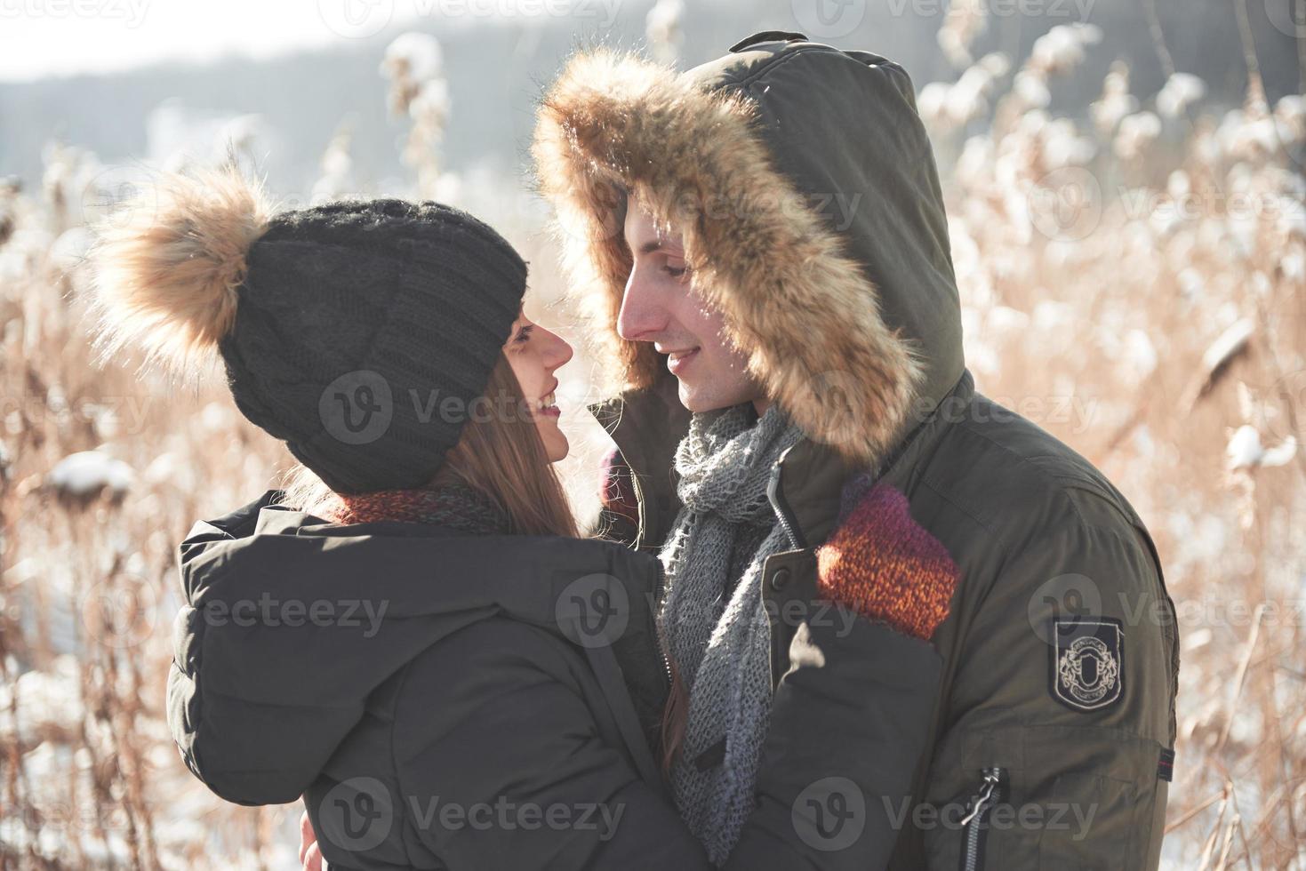 Happy couple playful together during winter holidays vacation outside in snow park photo