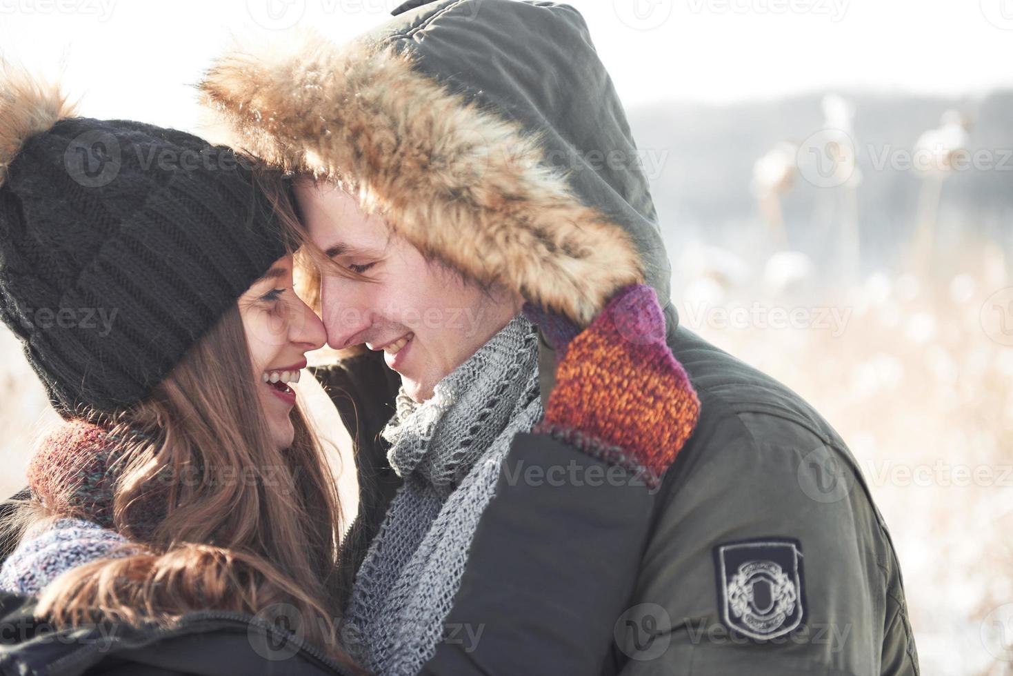 la pareja se divierte y se ríe. Beso. Pareja joven inconformista abrazándose en Winter Park. historia de amor de invierno, una hermosa joven pareja con estilo. concepto de moda de invierno con novio y novia foto