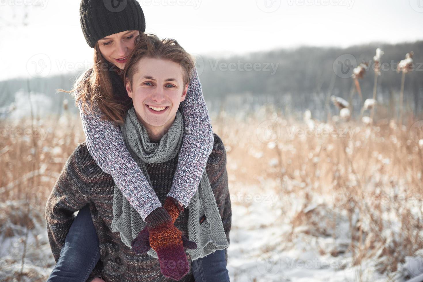 Happy young couple has fun on fresh snow at beautiful winter sunny day on vacation photo