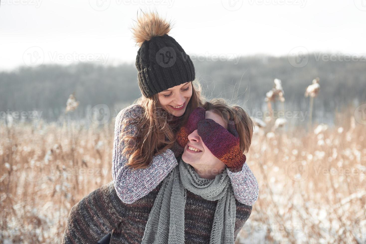 la pareja se divierte y se ríe. Beso. Pareja joven inconformista abrazándose en Winter Park. historia de amor de invierno, una hermosa joven pareja con estilo. concepto de moda de invierno con novio y novia foto