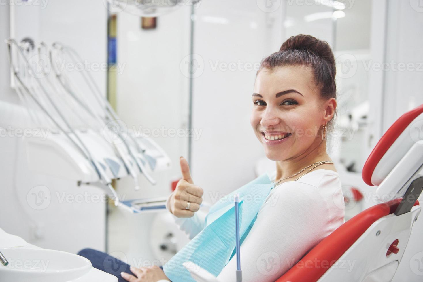 Paciente satisfecho mostrando su sonrisa perfecta después del tratamiento en una clínica dentista foto