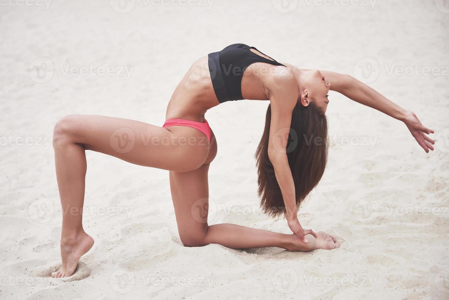 hermosa chica de lujo delgada en bikini en la playa de arena en una isla tropical. sexy cuerpo bronceado y figura perfecta foto