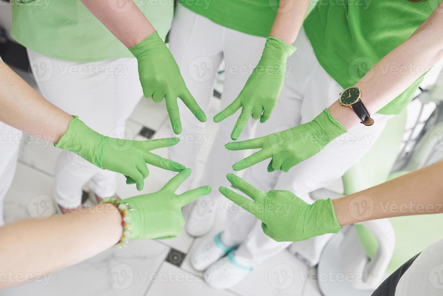 médicos y enfermeras en un equipo médico apilando las manos foto