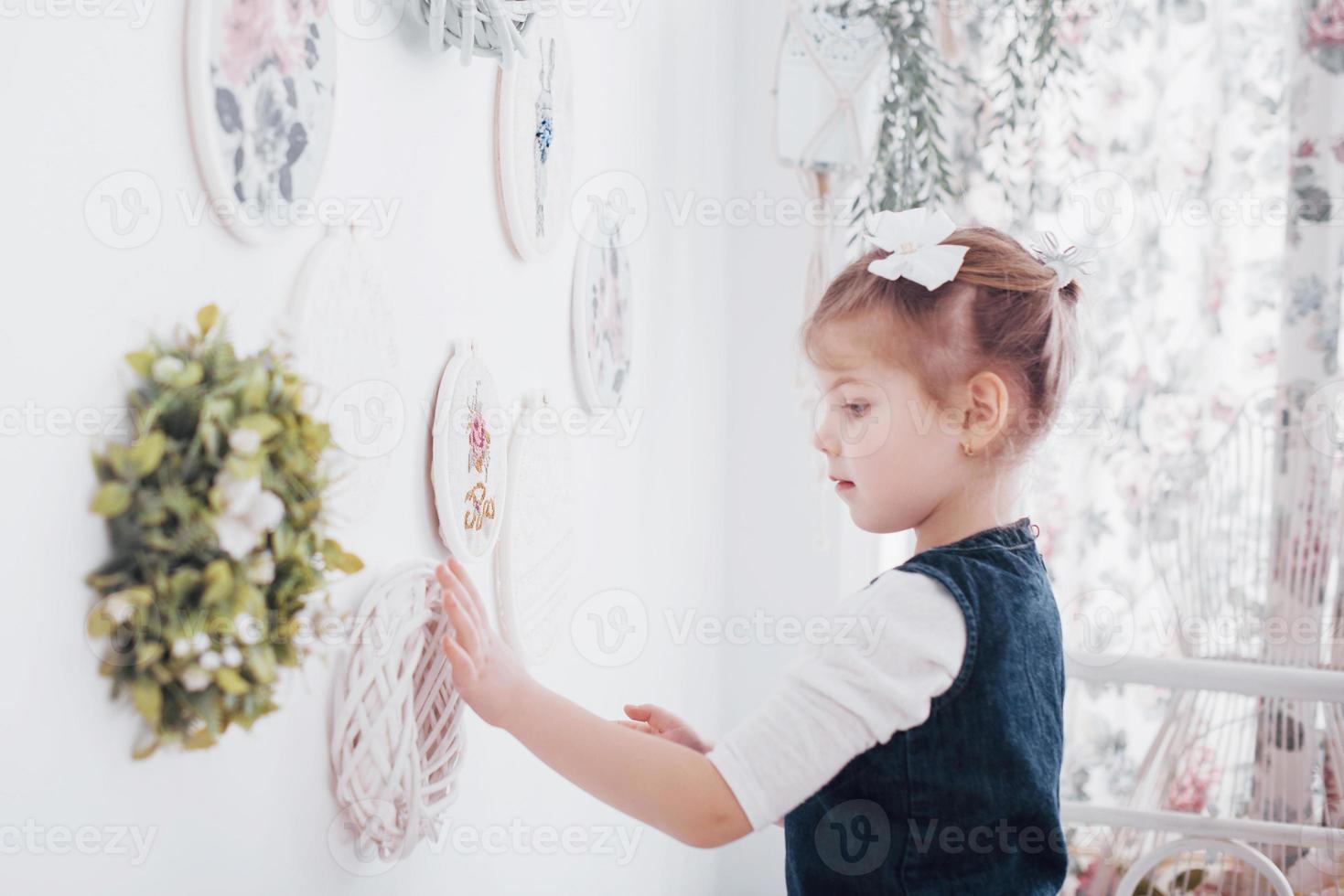 niña cerca del espejo. una pequeña fashionista en el dormitorio foto