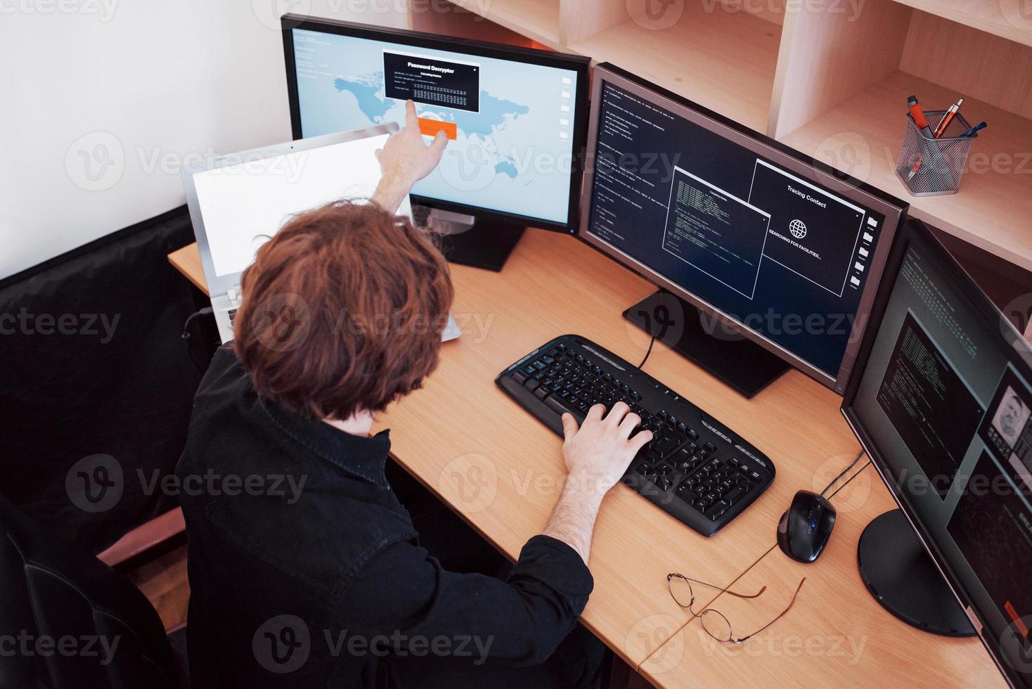 Male programmer working on desktop computer with many monitors at office in software develop company. Website design programming and coding technologies photo