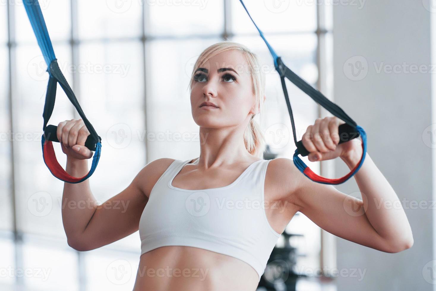 Women doing push ups training arms with trx fitness straps in the gym Concept workout healthy lifestyle sport photo