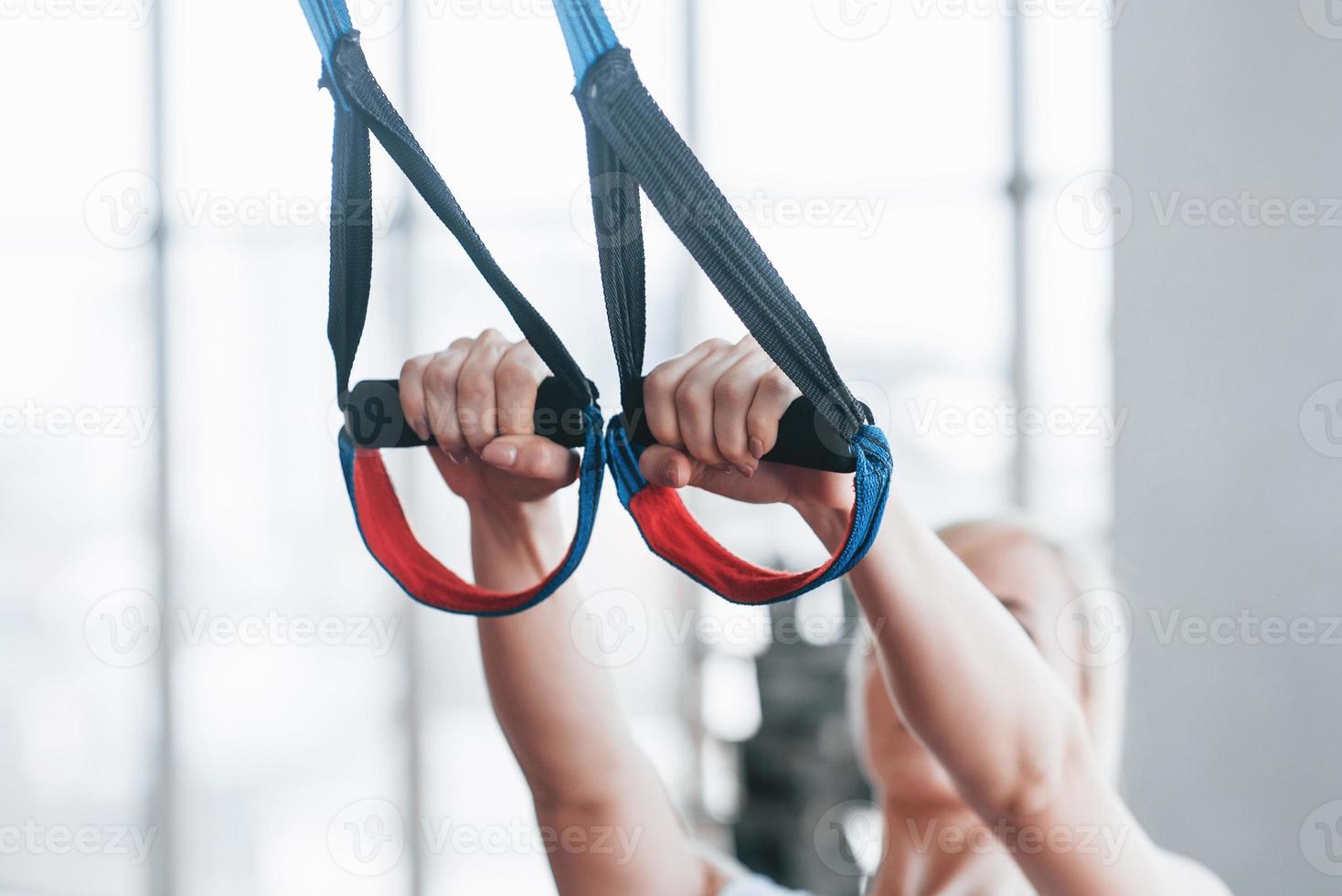 Women doing push ups training arms with trx fitness straps in the gym Concept workout healthy lifestyle sport photo