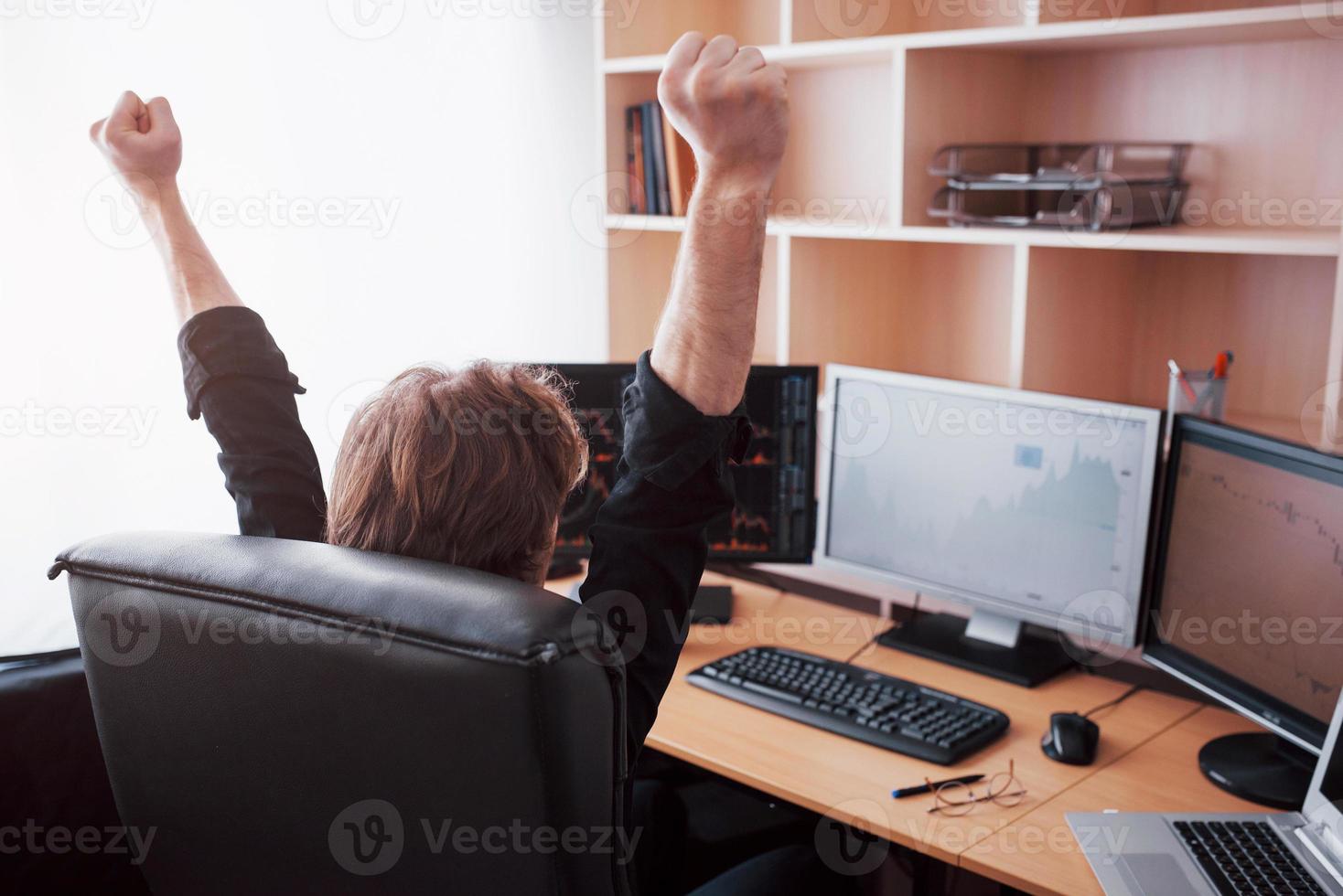 Young stock trader broker stretching hands at workplace, he first achieved great success on the stock market photo