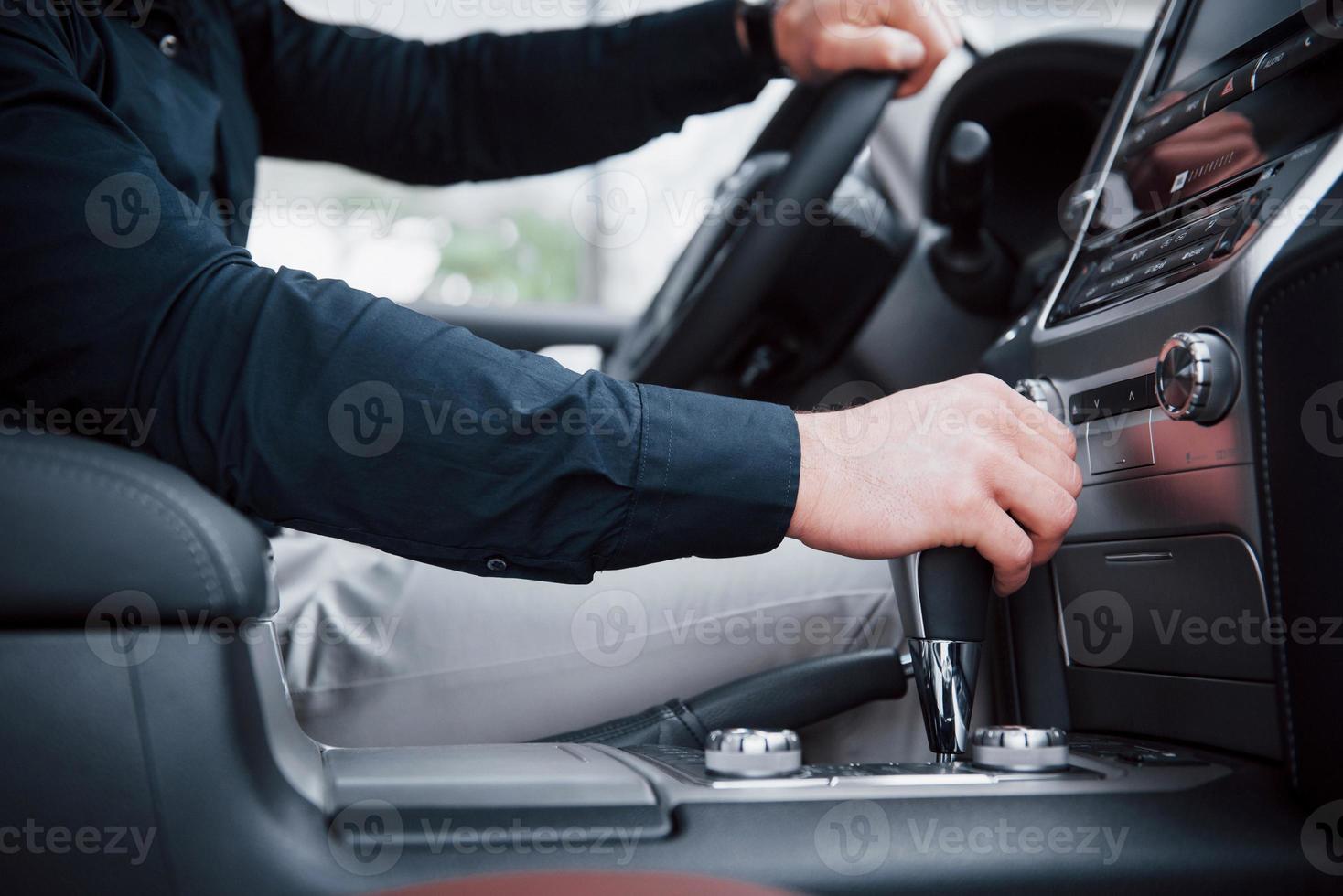 Close up view of a young man driving a car. Start a business trip. Test drive a new auto photo