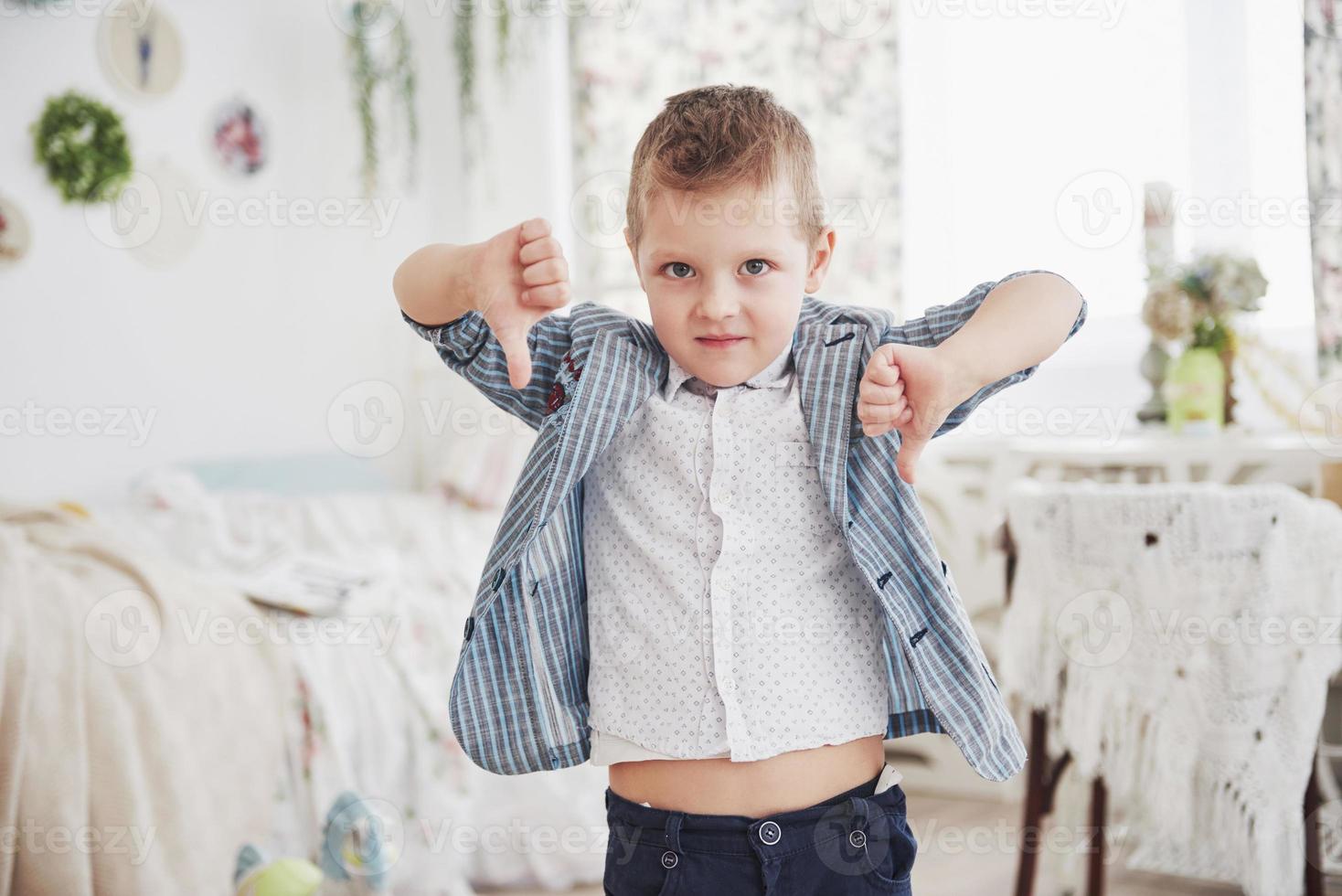 chico hace un gesto con el dedo hacia abajo. concepto de emoción. muestra su actitud hacia las lecciones y las escuelas foto