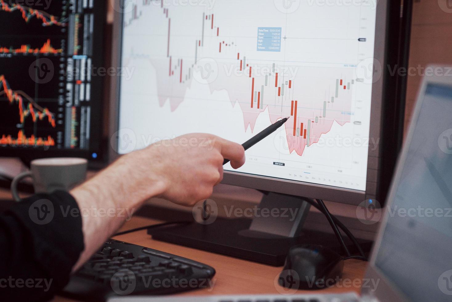 analizar datos. Close-up de joven empresario apuntando a los datos presentados en el gráfico con lápiz mientras trabajaba en la oficina creativa foto