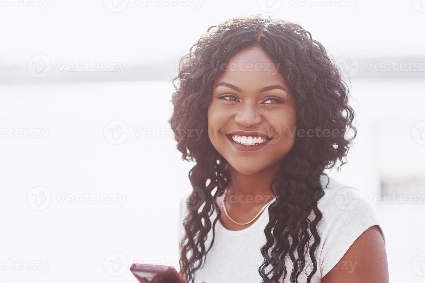 retrato, de, sonriente, joven, mujer negra, con, luz del sol, destello foto