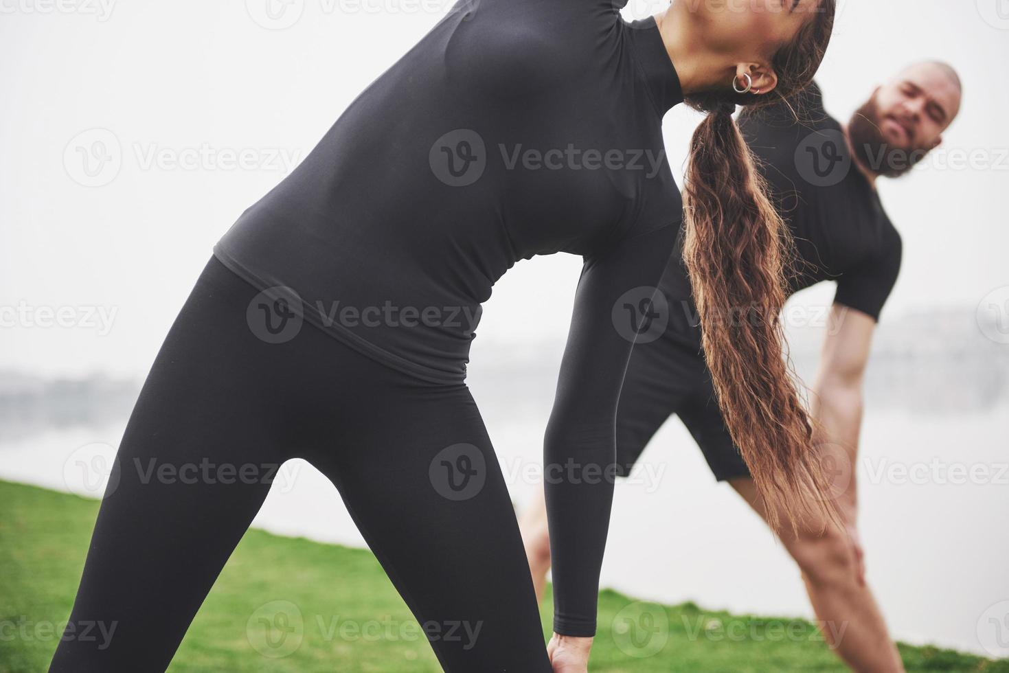 A young couple enjoys playing sports in the morning in the open air. Warm up before exercise photo