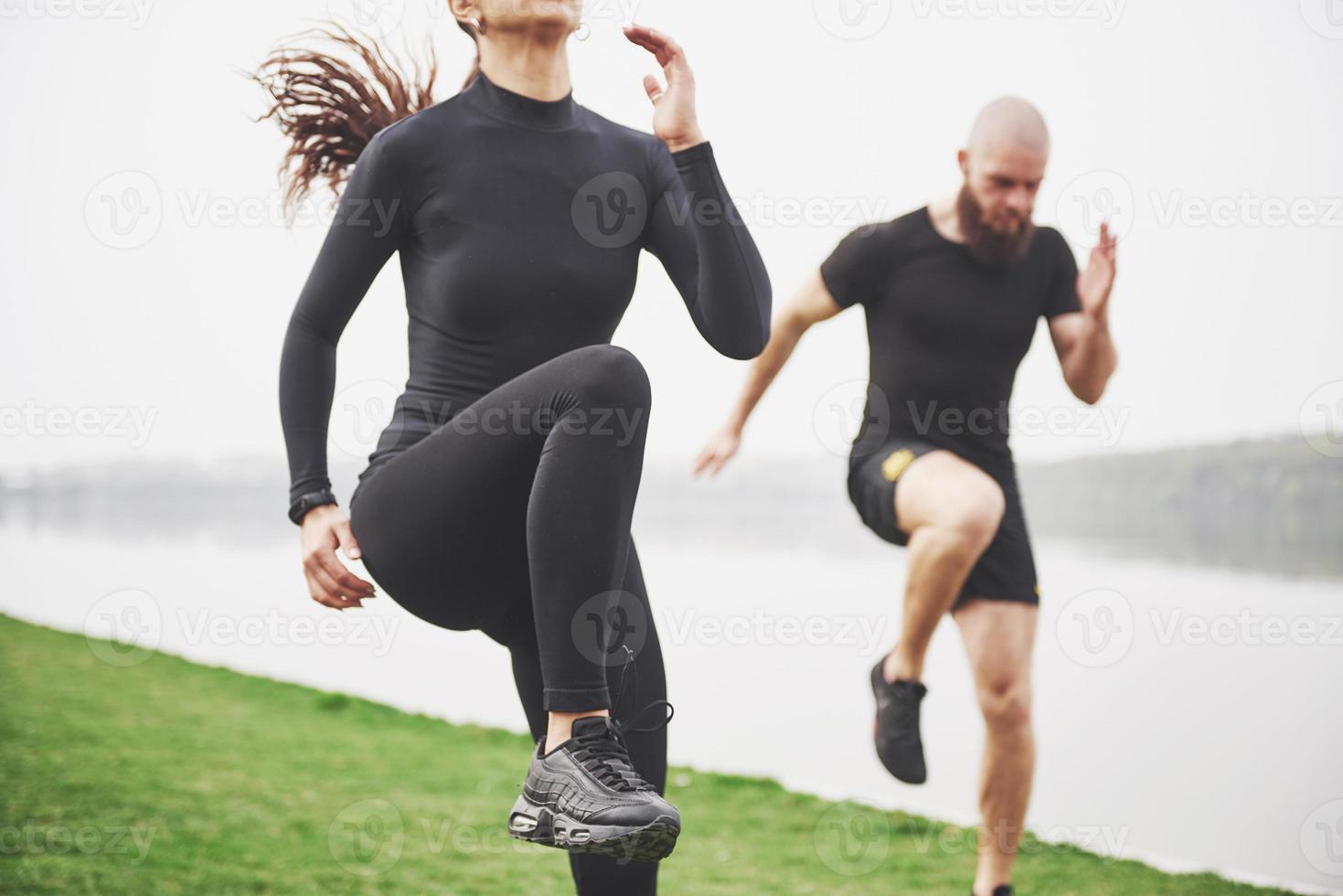 A young couple enjoys playing sports in the morning in the open air. Warm up before exercise photo