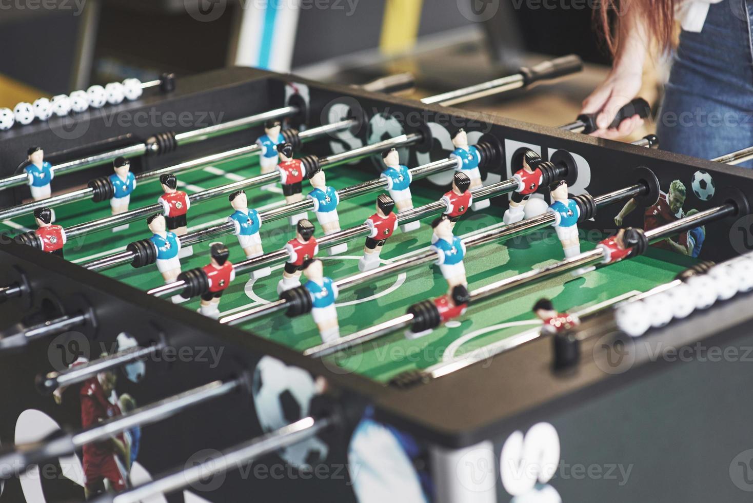 futbolín en el centro de entretenimiento. Imagen cercana de jugadores de plástico en un partido de fútbol. foto