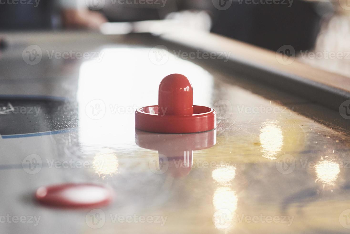 Air hockey table with window lighting and red toy hockey stick photo