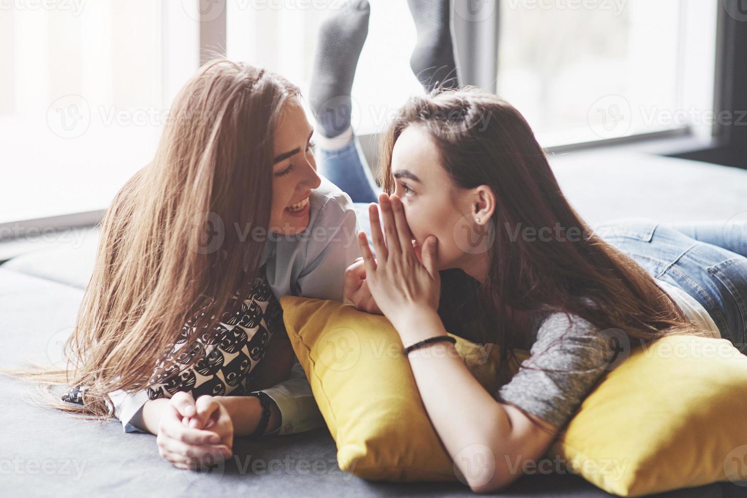 dos hermosas hermanas gemelas jóvenes pasar tiempo juntos con almohadas. hermanos que se divierten en el concepto de casa foto